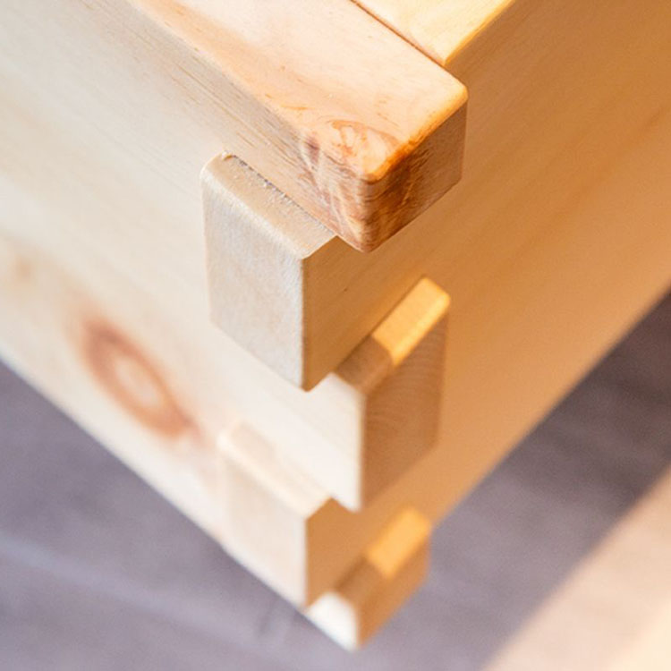 Das Bild zeigt eine Holzverbindung mit Zinken, hergestellt aus Buchenholz.