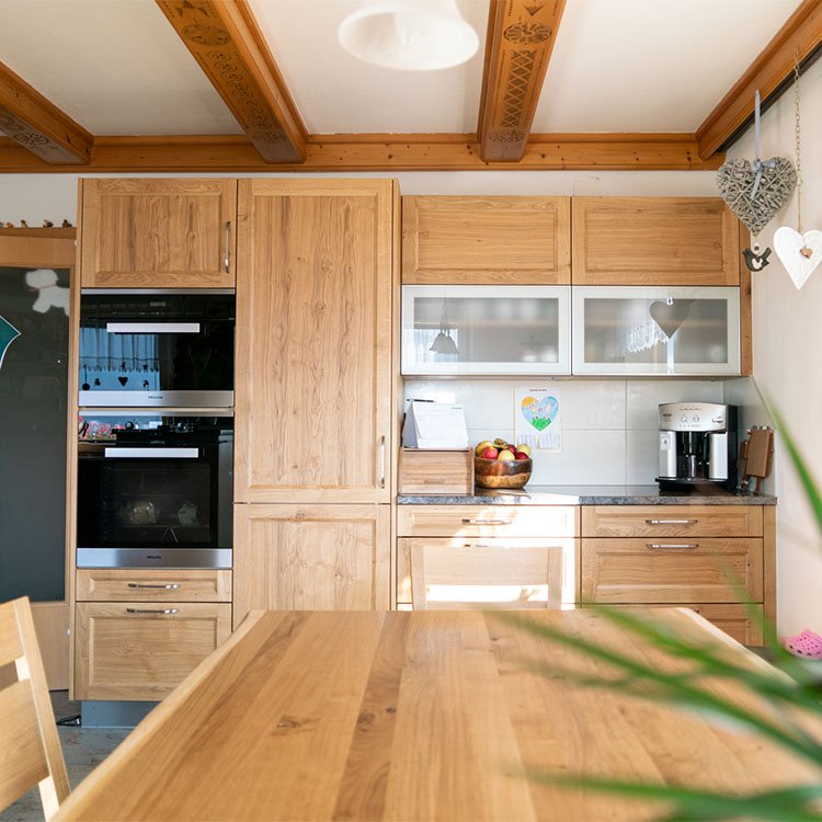 Küche im Landhausstil, die aus Eiche gefertigt ist.